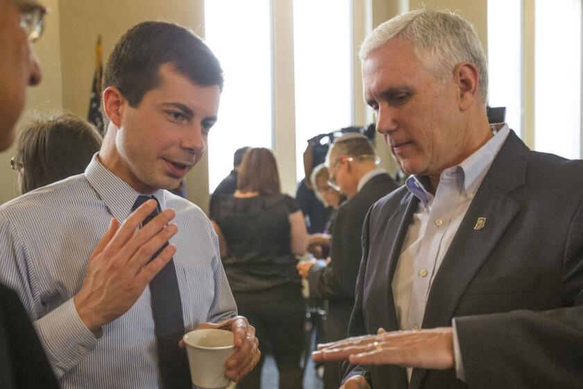 FILE - In this May 1, 2015, file photo, then-Indiana Gov. Mike Pence, right, talks with South Bend Mayor Pete Buttigieg during a visit to recap the legislative session that ends in South Bend. Democratic presidential candidate Pete Buttigieg blasts Vice President Mike Penceâs religious conservatism. But as the mayor of South Bend, Indiana, his tone toward the stateâs former governor was more muted. The two once had a cordial relationship. (Robert Franklin/South Bend Tribune via AP)