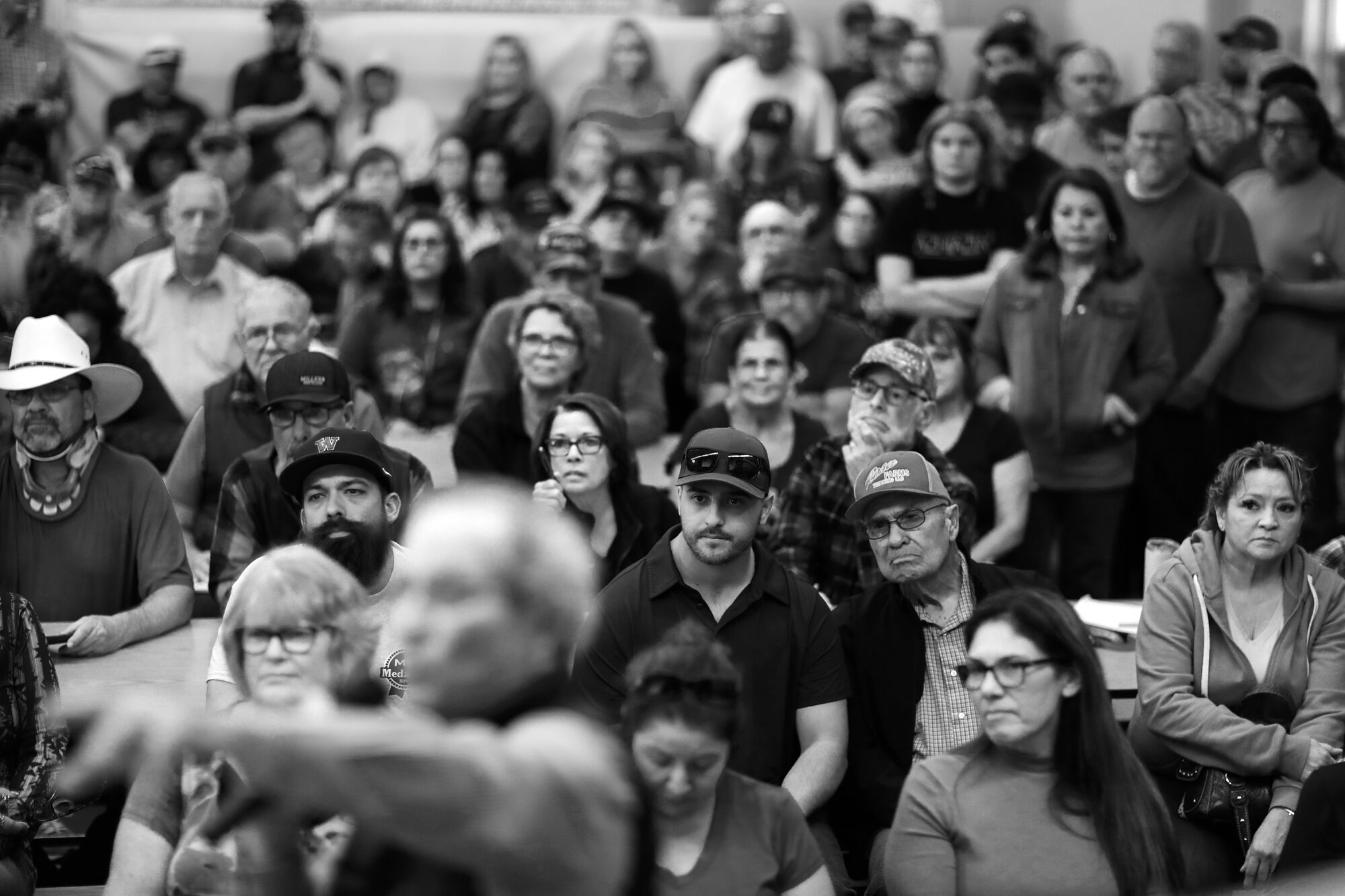 A large room is crowded with people gazing intently.