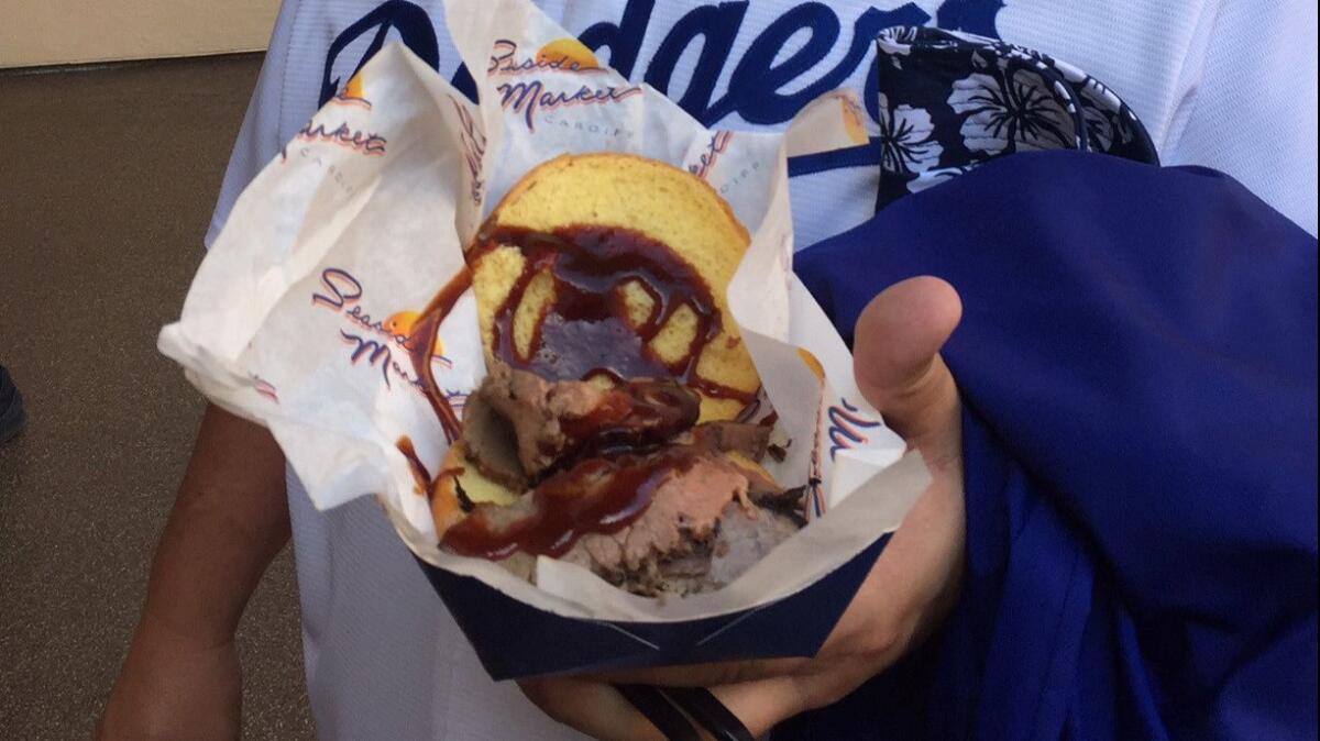 Dodgers fan Steve Cardenas shows off a tri-tip sandwich — a big hit at Petco Park in San Diego.