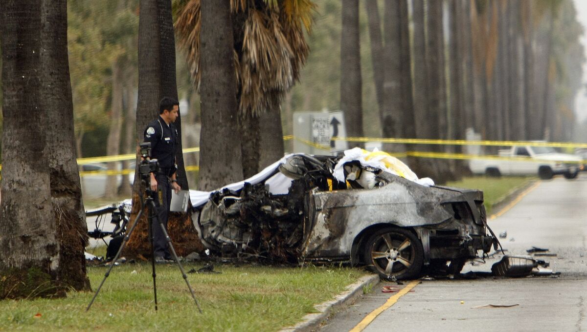 An LAPD officer investigates the scene of a single-vehicle accident in which journalist Michael Hastings was killed when his vehicle crashed into a tree and caught fire in Hancock Park.