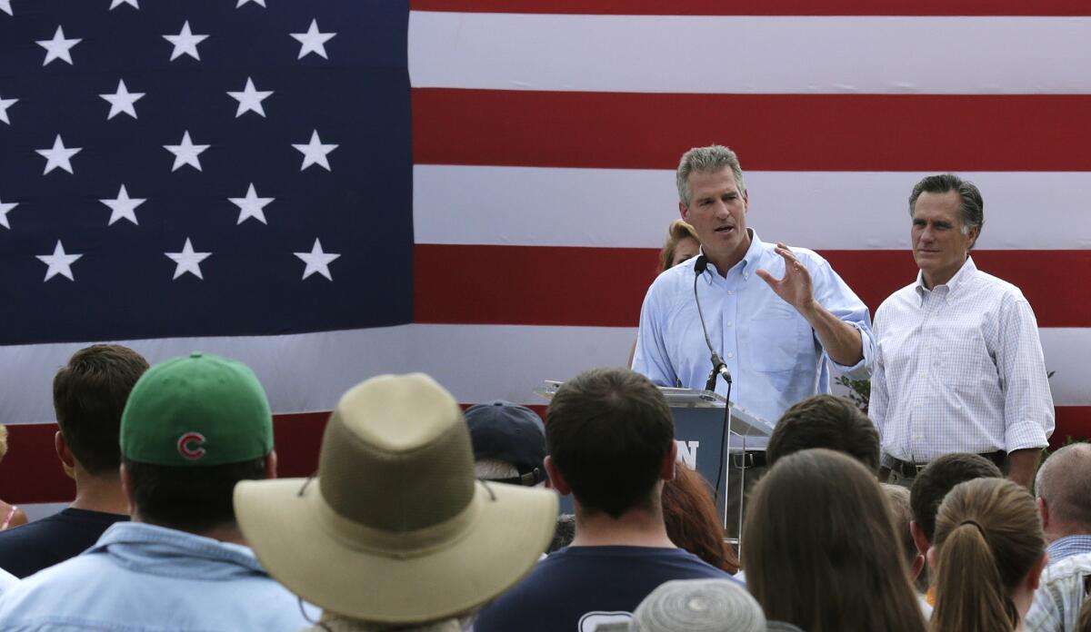 New Hampshire Senate candidate Scott Brown, left, addresses a gathering of supporters with Mitt Romney, the former Republican presidential nominee, at his side during a campaign stop at a farm in Stratham, N.H., on July 2. Brown, who is facing incumbent Democrat U.S. Sen. Jeanne Shaheen, was endorsed by Romney at the event.