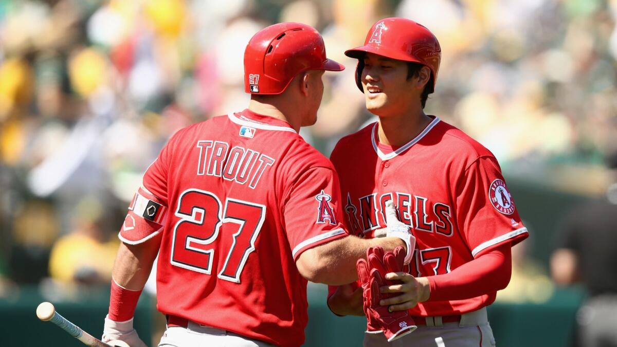 Shohei Ohtani of the Angels is congratulated by Mike Trout after getting his first major league hit on opening day last season..
