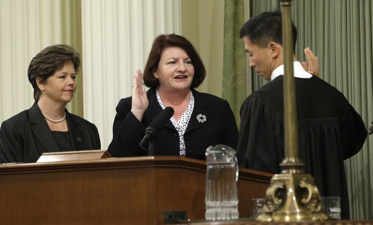 Assemblywoman Toni Atkins (D-San Diego), center, is sworn in as Assembly speaker by California Supreme Court Associate Justice Goodwin Liu, as her spouse, Jennifer LeSar, left, watches at the Capitol on Monday.