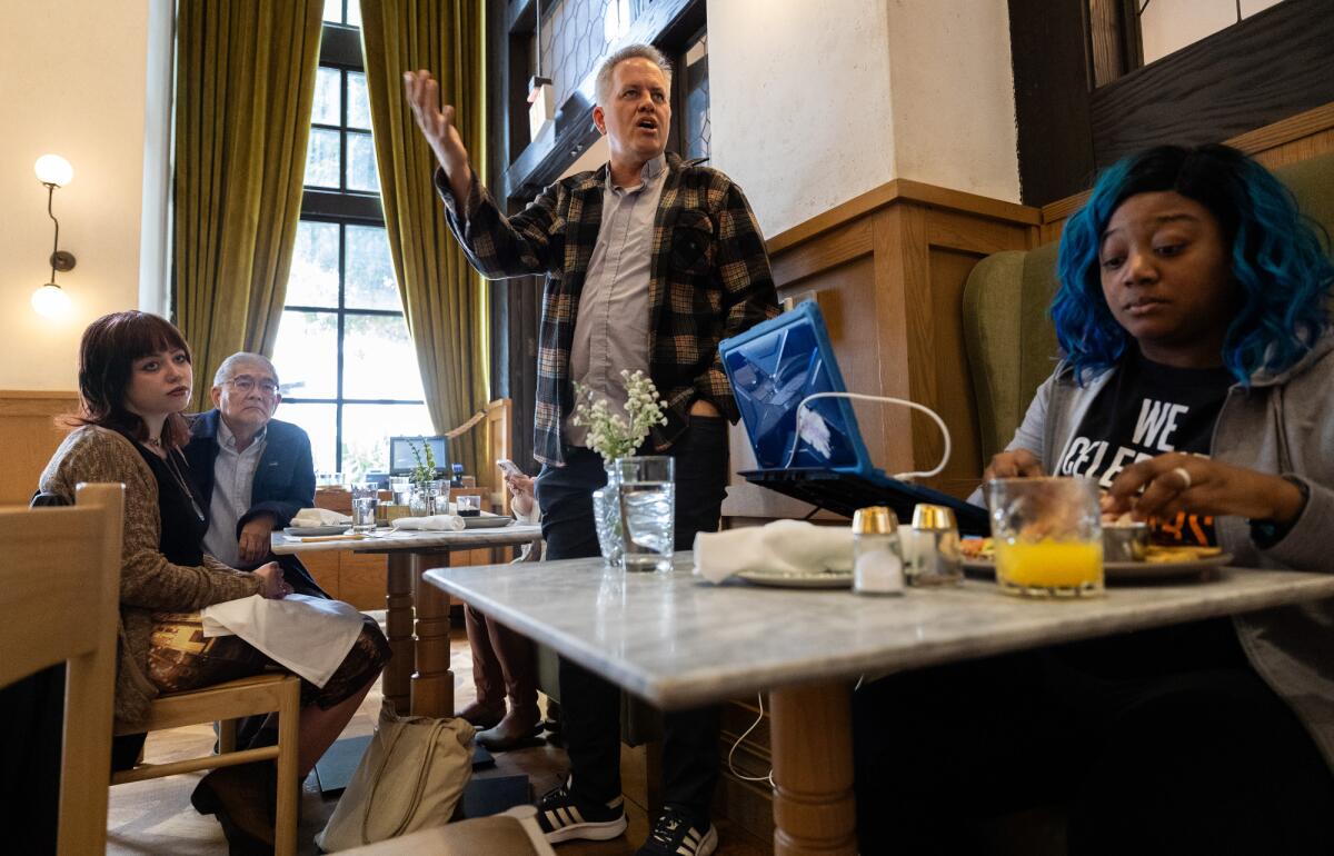Rev. Andrew Schwiebert, center, talks with diners as he and dozens of others participate in a "water-in" at the Café Fig.