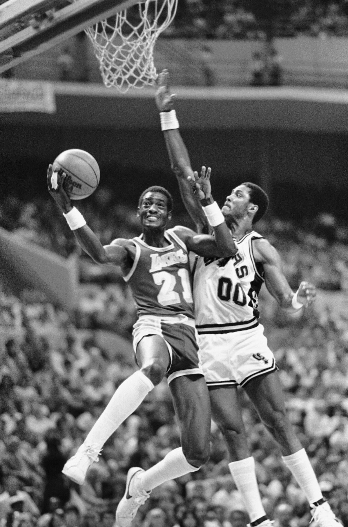 Lakers forward Michael Cooper attempts a layup against Spurs guard Johnny Moore during Game 4 of their playoff series in 1983