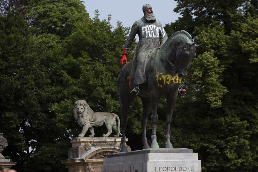 In this June 10, 2020, photo, a statue of Belgium's King Leopold II is smeared with paint and graffiti in the center of Brussels. With the protests sweeping the world in the wake of the killing of George Floyd in Minneapolis, King Leopold II, who reigned from 1865 to 1909, is now increasingly seen as a stain on the nation. (AP Photo/Virginia Mayo)