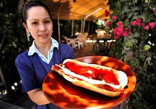 Elena Piña, deli manager at La Española Meats in Harbor City, holds the jamón serrano sandwich that's served at lunch. It comes with a cup full of olives cured in a tomato sauce, and together they can be eaten out back on a picnic table under an arbor shaded wtih bougainvillea. $4.95.