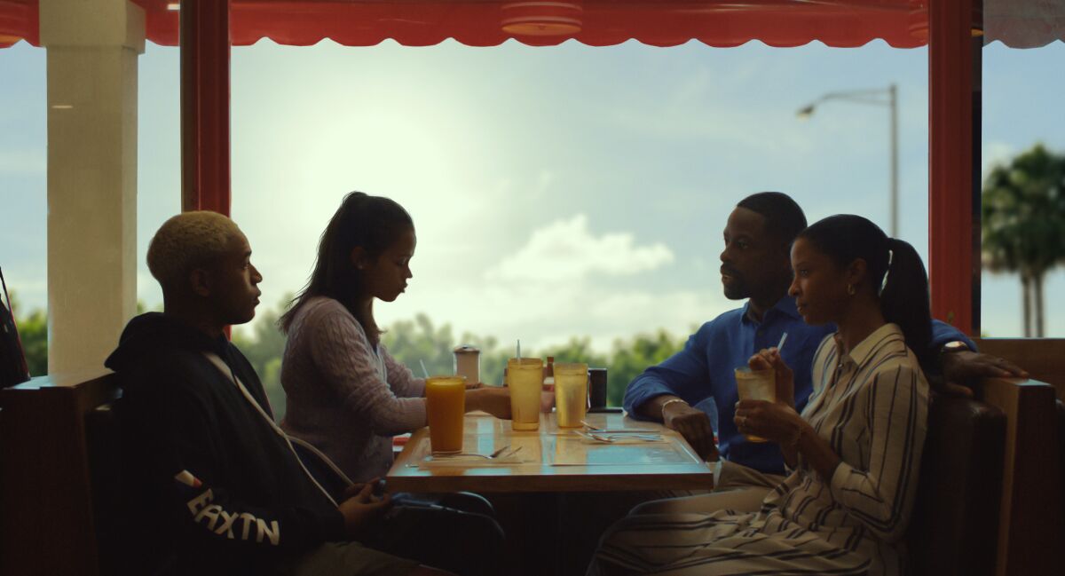 Kelvin Harrison Jr., Taylor Russell, Sterling K. Brown and Renée Elise Goldsberry sit at a restaurant booth in "Waves."
