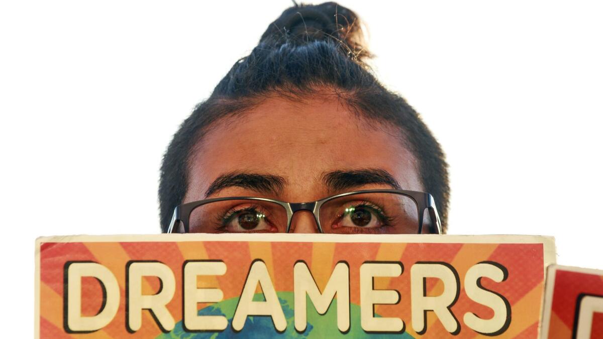 Alexis Torres holds a sign during a rally, put on by the San Diego Border Dreamers, marking the anniversary of the Trump Administration's attempt to end the DACA program at the County Administration Building in San Diego on Wednesday.