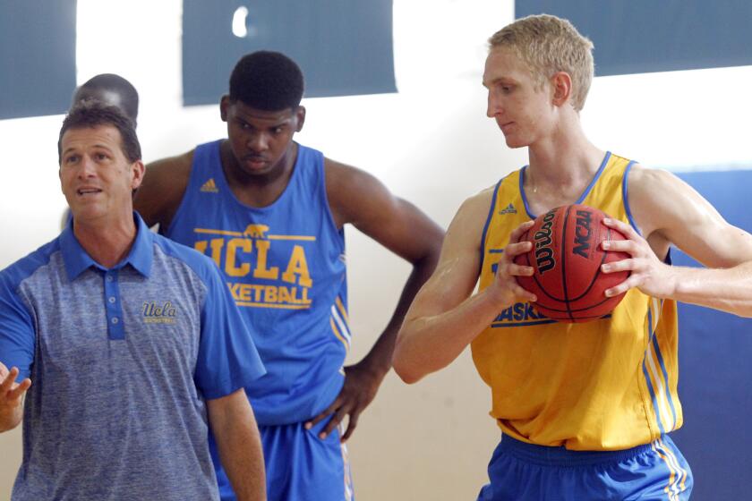 UCLA Coach Steve Alford speaks as Tony Parker, center, and Thomas Welsh look on during a practice session last season.