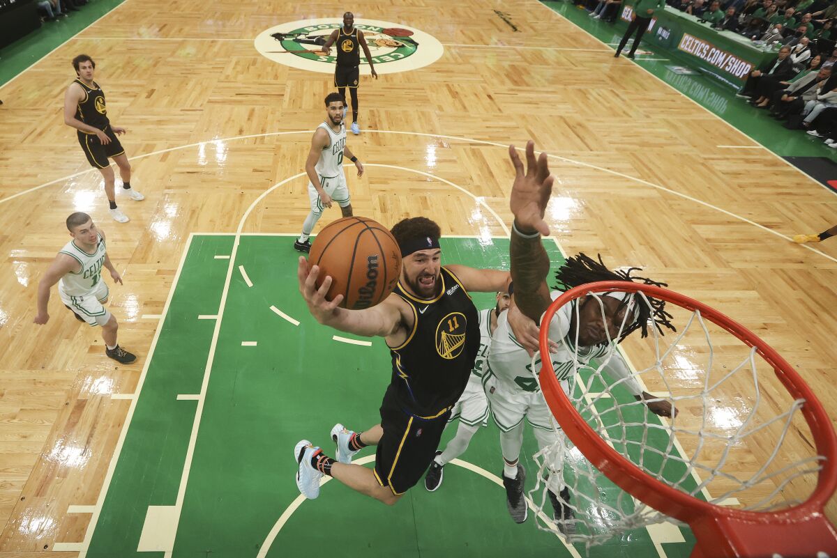 Golden State Warriors guard Klay Thompson (11) puts up a shot against Boston Celtics center Robert Williams III (44) during the second half of Game 3 of basketball's NBA Finals, Wednesday, June 8, 2022, in Boston. (Kyle Terada/Pool Photo via AP)