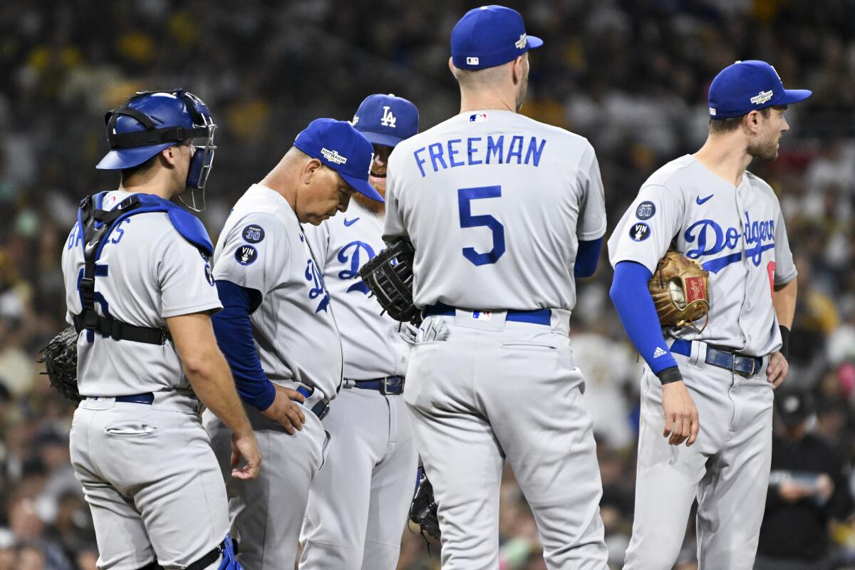 Dodgers manager Dave Roberts waits with his players during a pitching change in Game 3.