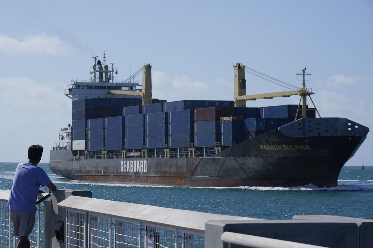 A man watches as the Warnow-Dolphin container ship sails to PortMiami, Thursday, April 29, 2021, in Miami Beach, Fla. The U.S. trade deficit widened in May as $71.2 billion as a small increase in exports was offset by a bigger rise in imports.The Commerce Department reported Friday that the deficit rose 3.1% from the revised April deficit of $69.1 billion The U.S. trade deficit had hit a monthly record of $75 billion in March. (AP Photo/Marta Lavandier)