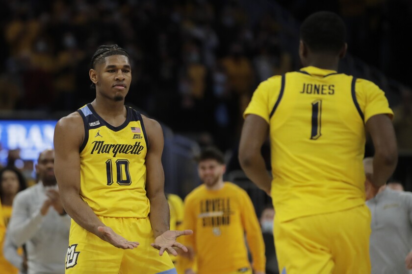 Marquette's Justin Lewis (10) congratulates Kam Jones (1) during the second half of an NCAA college basketball game against Xavier Sunday, Jan. 23, 2022, in Milwaukee. (AP Photo/Aaron Gash)