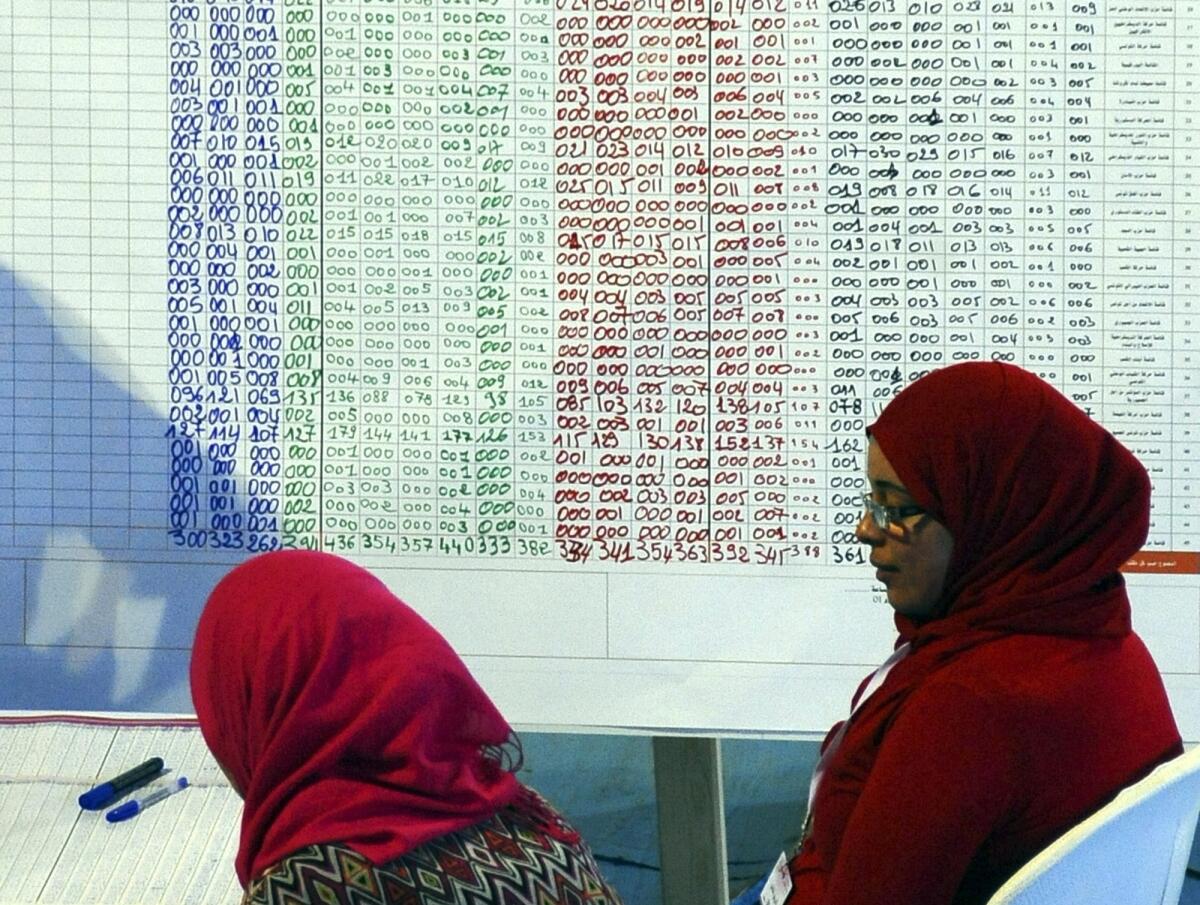 Tunisian civil servants look at election results in a Tunis voting center on Oct. 27.