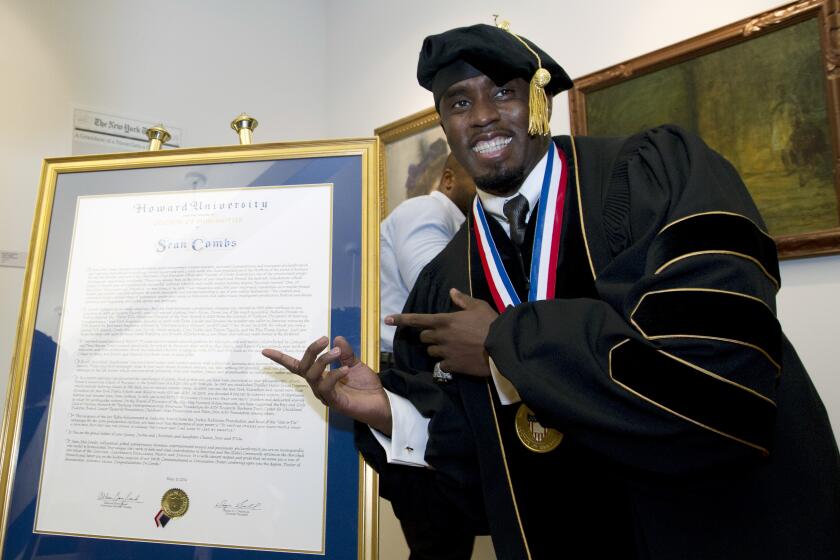 ARCHIVO - El artista y empresario Sean "Diddy" Combs posa junto a su título honorífico de Doctor en Humanidades durante la ceremonia de graduación en la Universidad Howard en Washington, el sábado 10 de mayo de 2014. En una decisión, el viernes 7 de junio de 2024, la Universidad Howard cortó lazos con Combs tras la difusión de un video donde golpea a su exnovia Cassie. (Foto AP/José Luis Magaña, Archivo)