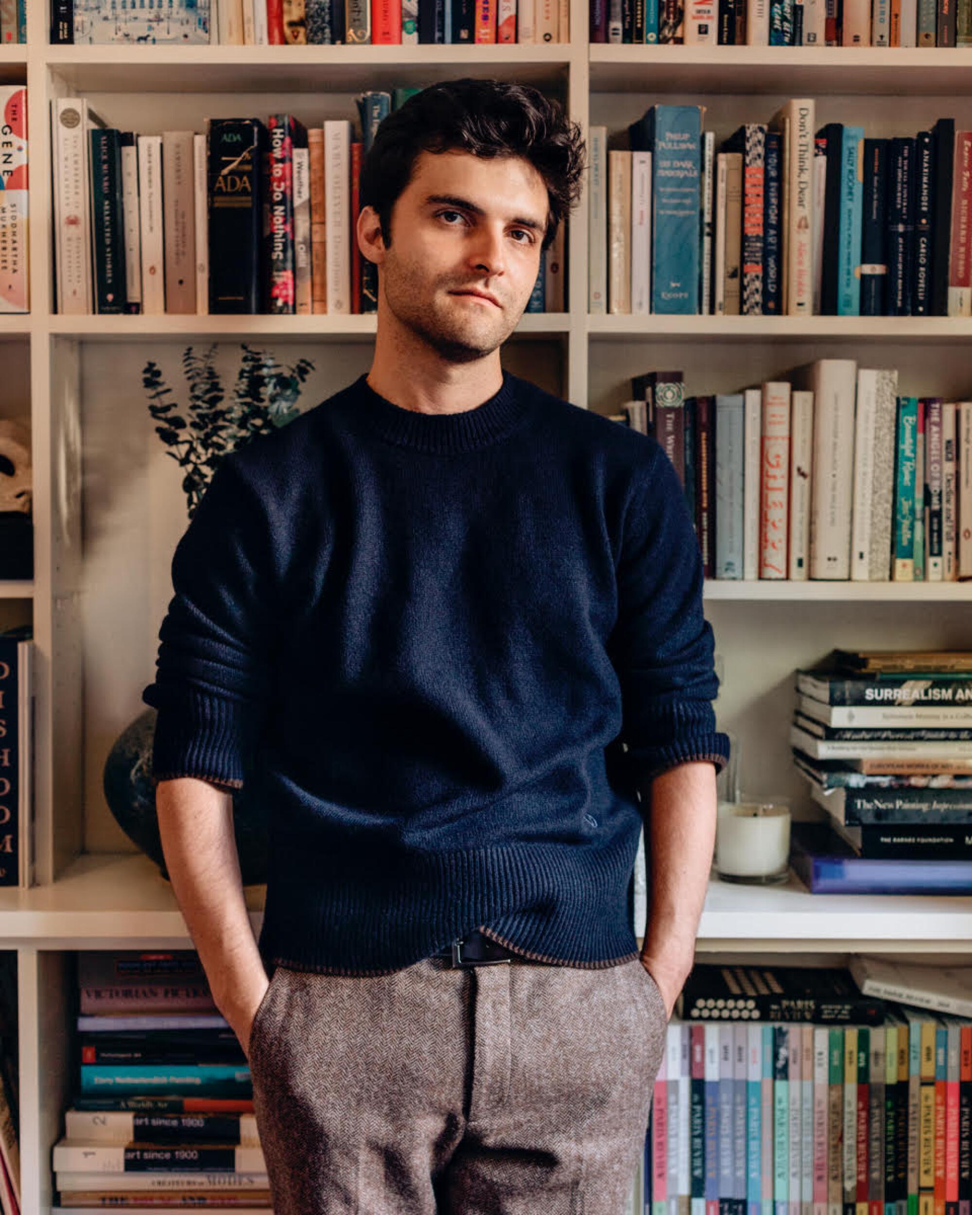 Portrait of Cody Delistraty standing in front of a bookshelf