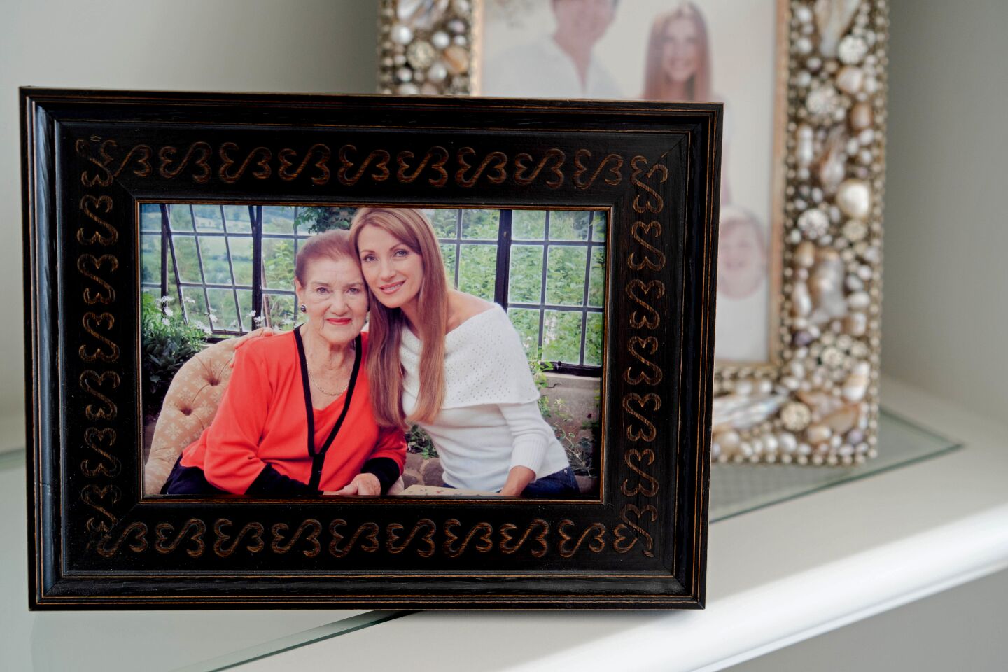 Framed photographs of Jane Seymour and her family fill the shelves.
