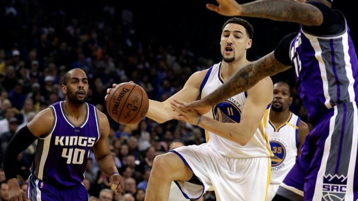 Warriors guard Klay Thompson (11) drives between Kings defenders Arron Afflalo (40) and DeMarcus Cousins, right, during the first half on Feb. 15.