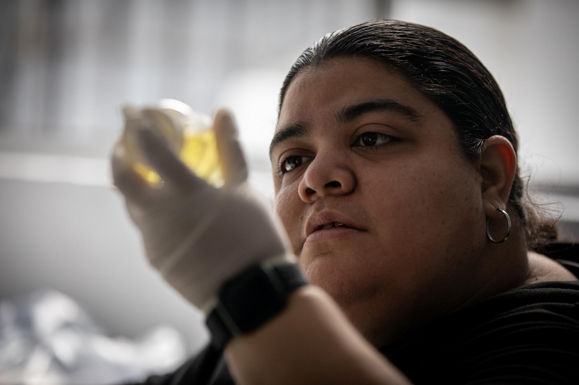 Sandra Mercado looks at a water sample in the lab