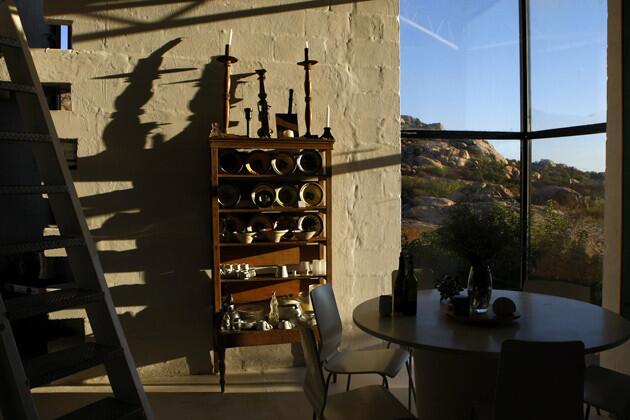 A hutch holds a mix of vintage Mexican dishes that the couple bought in Puebla from a man on the street. An office conference table was repurposed as the dining table.