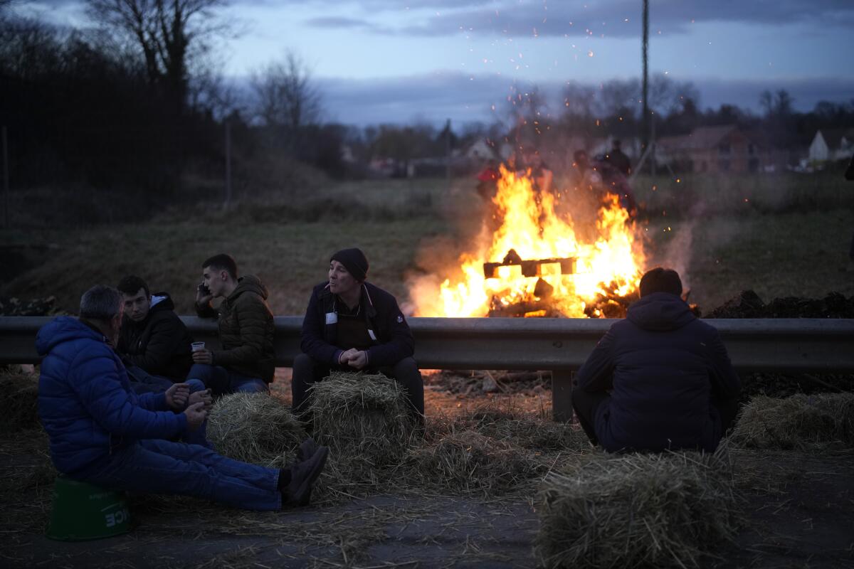 Farmers relax by a bonfire outside Paris.