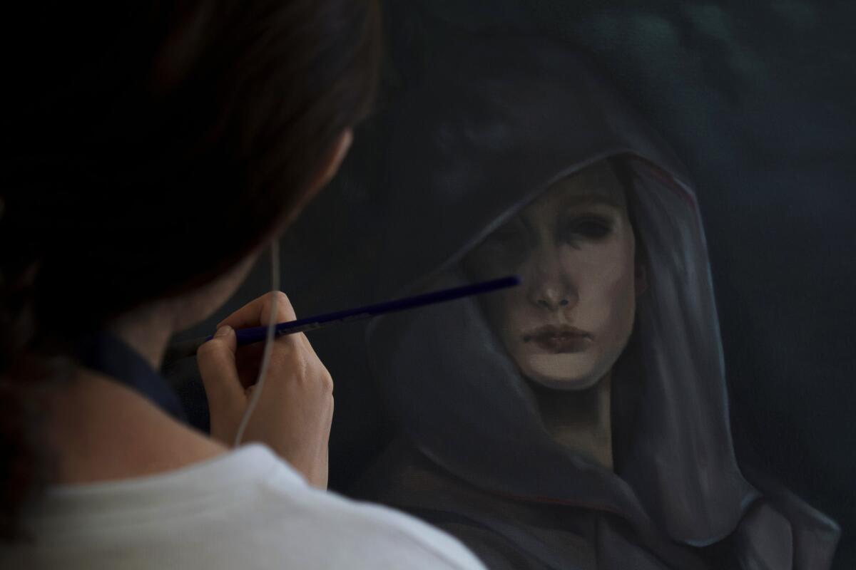 Artist Leslye Villaseñor paints a canvas.