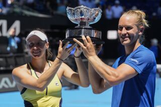 La brasileña Luisa Stefani y su compatriota Rafael Matos posan con el trofeo de campeones de dobles mixtos del Abierto de Australia, el iernes 27 de enero de 2023 (AP Foto/Dita Alangkara)