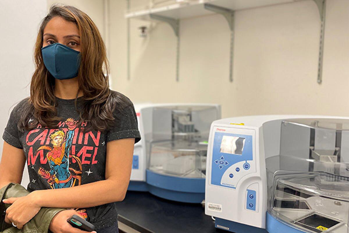 Smruthi Karthikeyan and the liquid-handling robotic platform used by UCSD researchers.