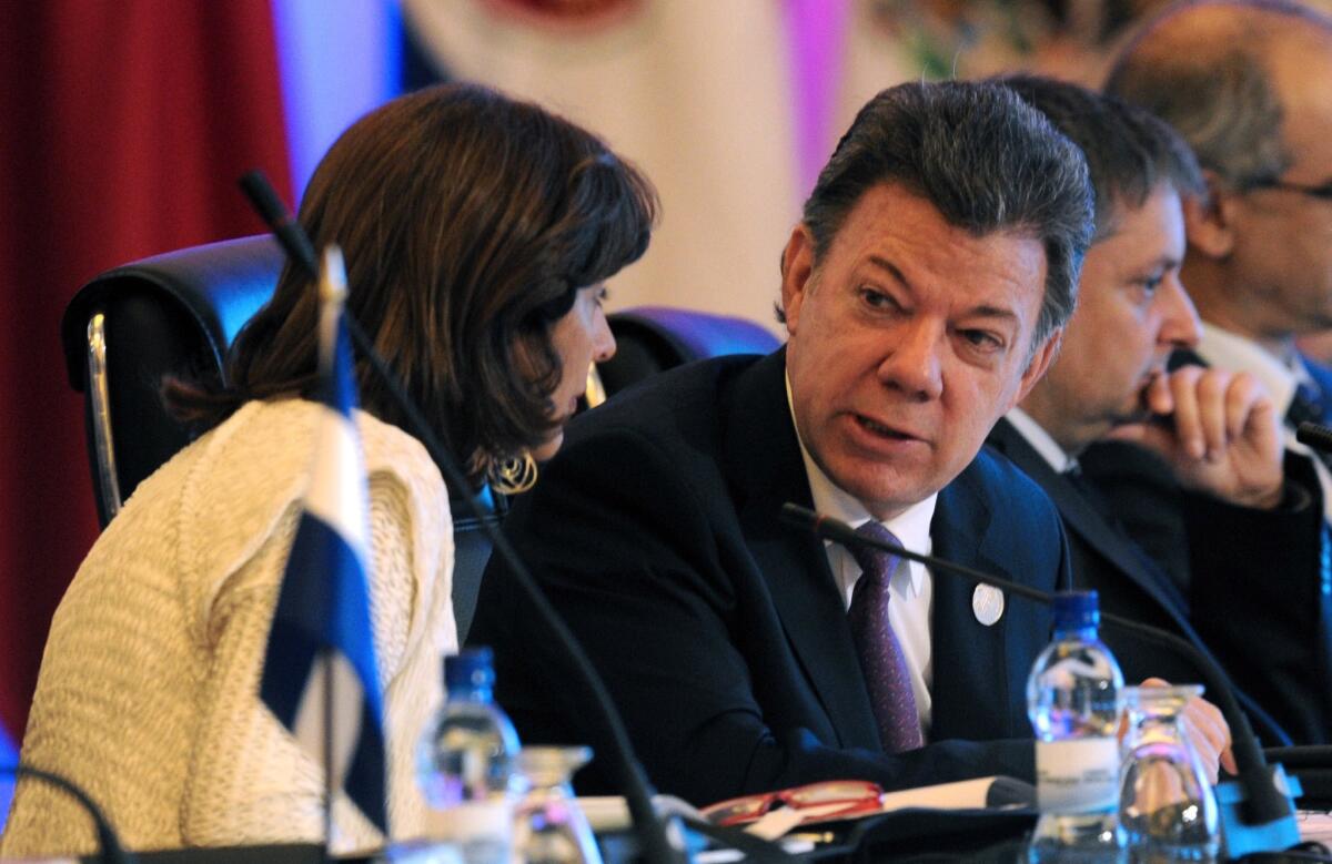 Colombian President Juan Manuel Santos speaks with Foreign Minister Maria Angela Holguin during the Ibero-American Summit in Panama City last month.