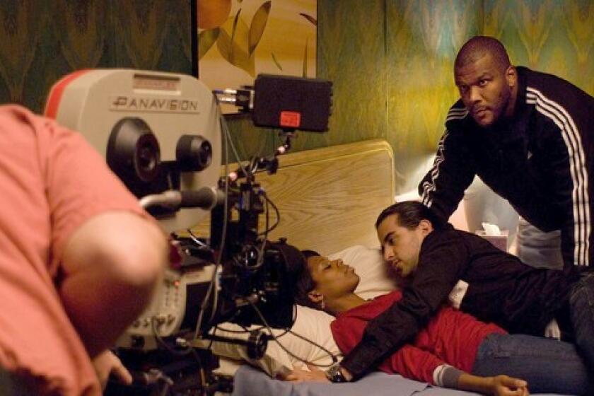Tyler Perry, right, directing on the set of his latest comedy, "Madea Goes to Jail," which was released Friday by Lionsgate. The stock of the studio's parent company has been hammered by investors after the company reported dismal quarterly results.