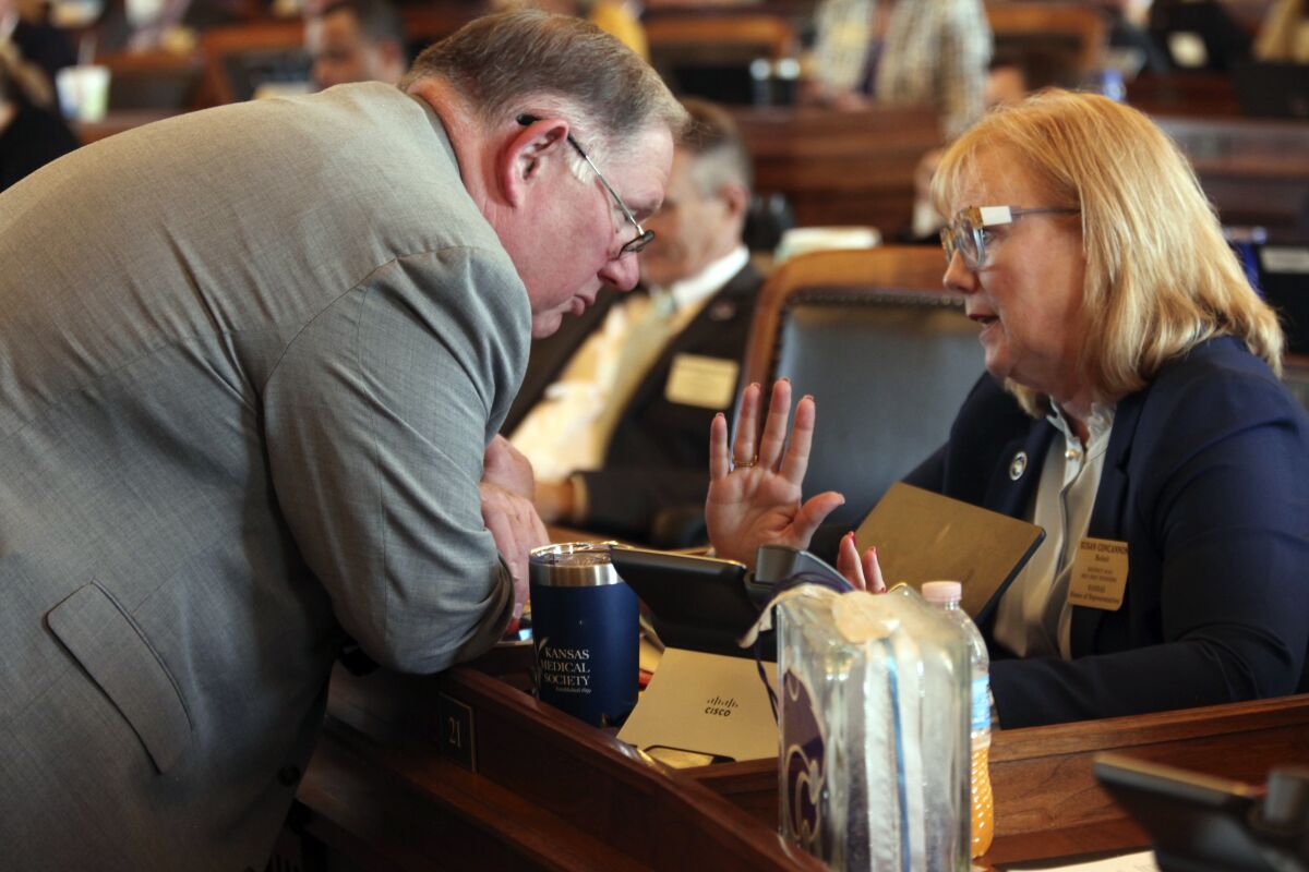 Kansas House Majority Leader Dan Hawkins, left, R-Wichita, confers with Rep. Susan Concannon, R-Beloit, during a debate on a GOP congressional redistricting plan, Wednesday, Feb. 9, 2022, at the Statehouse in Topeka, Kan. Republicans overrode Democratic Gov. Laura Kelly's veto of the plan, which makes it harder for the only Kansas Democrat in Congress to win reelection. (AP Photo/John Hanna)
