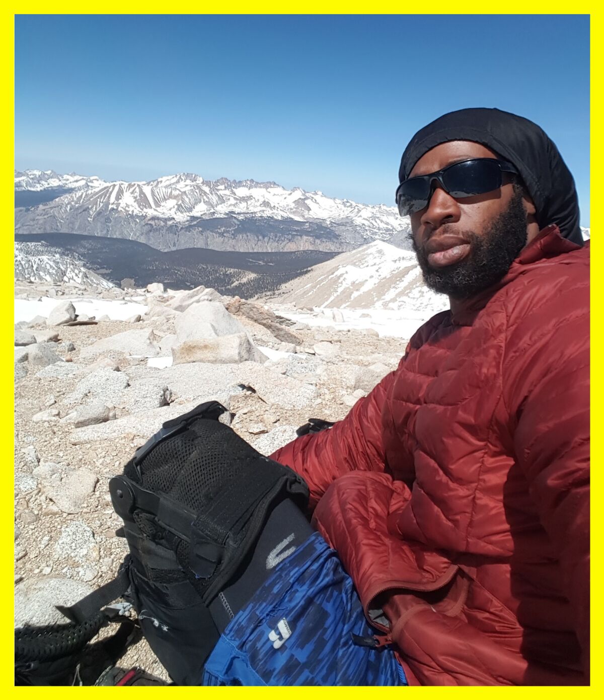 Akuna Robinson takes a selfie at the top of a snowy mountain.