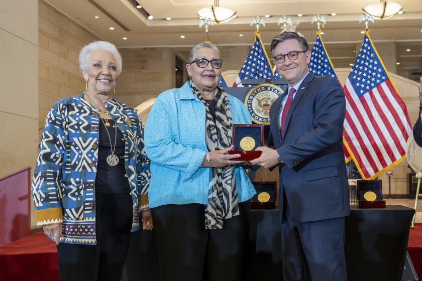 El presidente de la Cámara de Representantes, Mike Johnson, entrega una Medalla de Oro del Congreso en forma póstuma a Joylette Hylick, izquierda, y Katherine Moore, hijas de Katherine Johnson, la matemática de raza negra de la NASA cuya historia es contada en la película "Hidden Figures" ("Talentos ocultos"), el miércoles 18 de septiembre de 2024, en el Capitolio, en Washington. (AP Foto/J. Scott Applewhite)