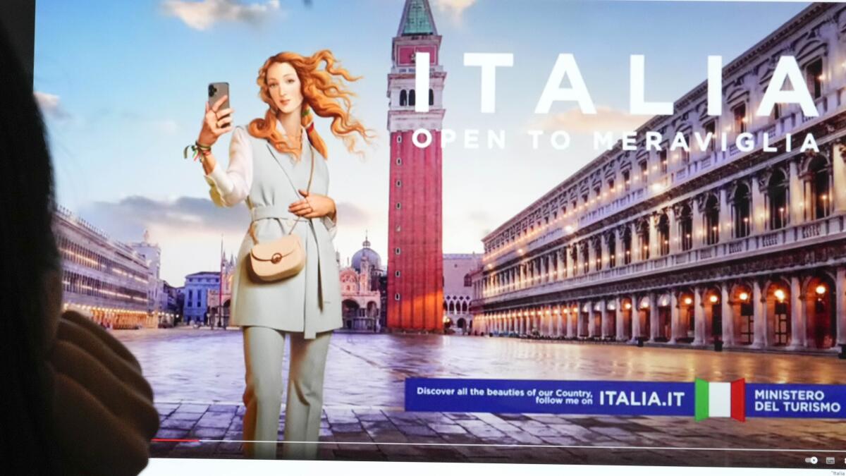 Unas personas observan un monitor con una campaña publicitaria del Ministerio de Turismo de Italia 