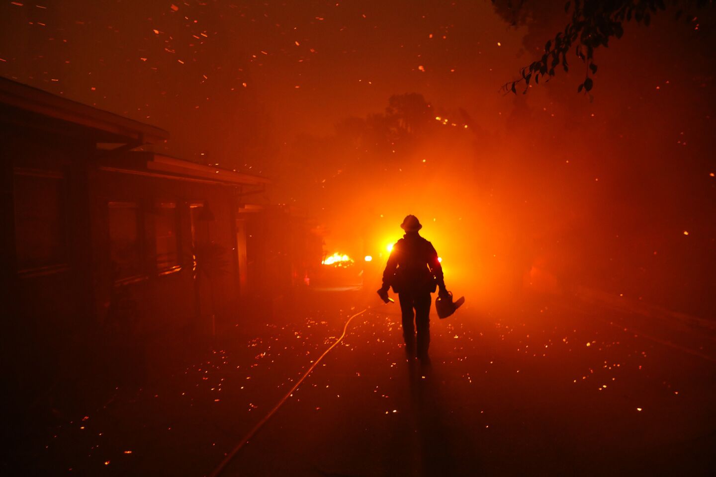 A firefighter walks towards his engine after trying to prevent the Woolsey fire from overtaking structures in Malibu.