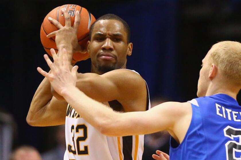 Wichita State's Tekele Cotton, left, looks to pass around Indiana State's Luca Eitel during the Shockers' Missouri Valley Conference title win on March 9.