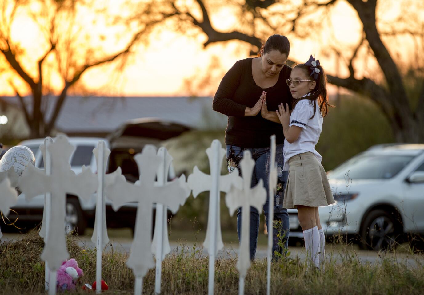 Meredith Cooper, of San Antonio, Texas, and her 8-year-old daughter, Heather, visit a memorial of 26 metal crosses near First Baptist Church in Sutherland Springs, Texas, on Nov. 6, 2017.
