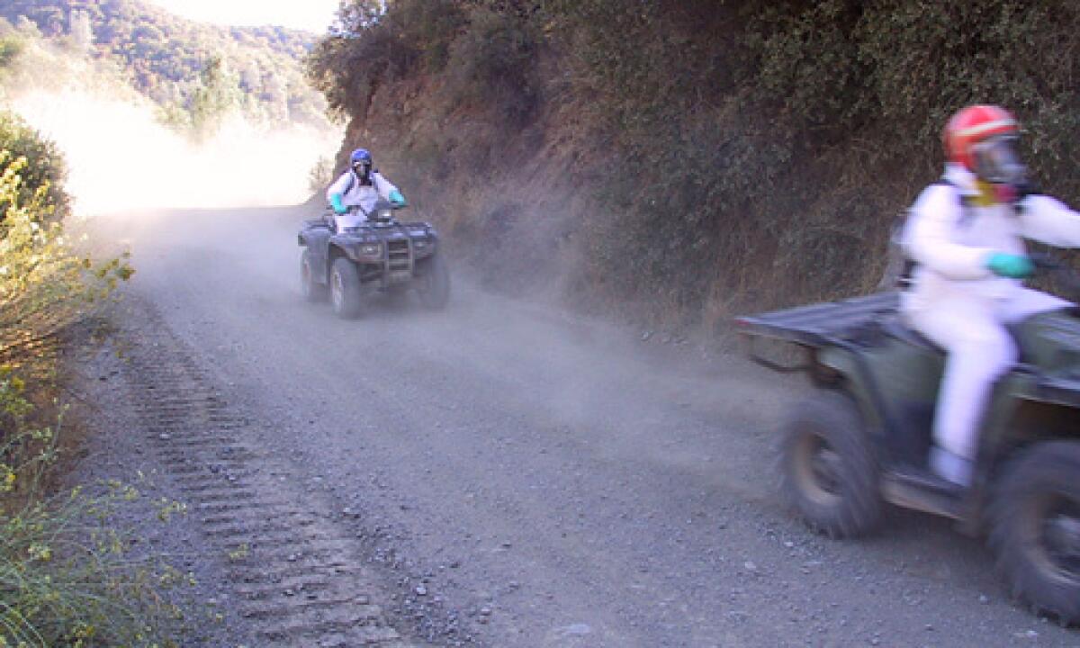 HAZARDOUS STUDY: Technicians on all-terrain vehicles sample the dust they raise at the Clear Creek Management Area. They are wearing backpacks with air pumps and filter intakes.