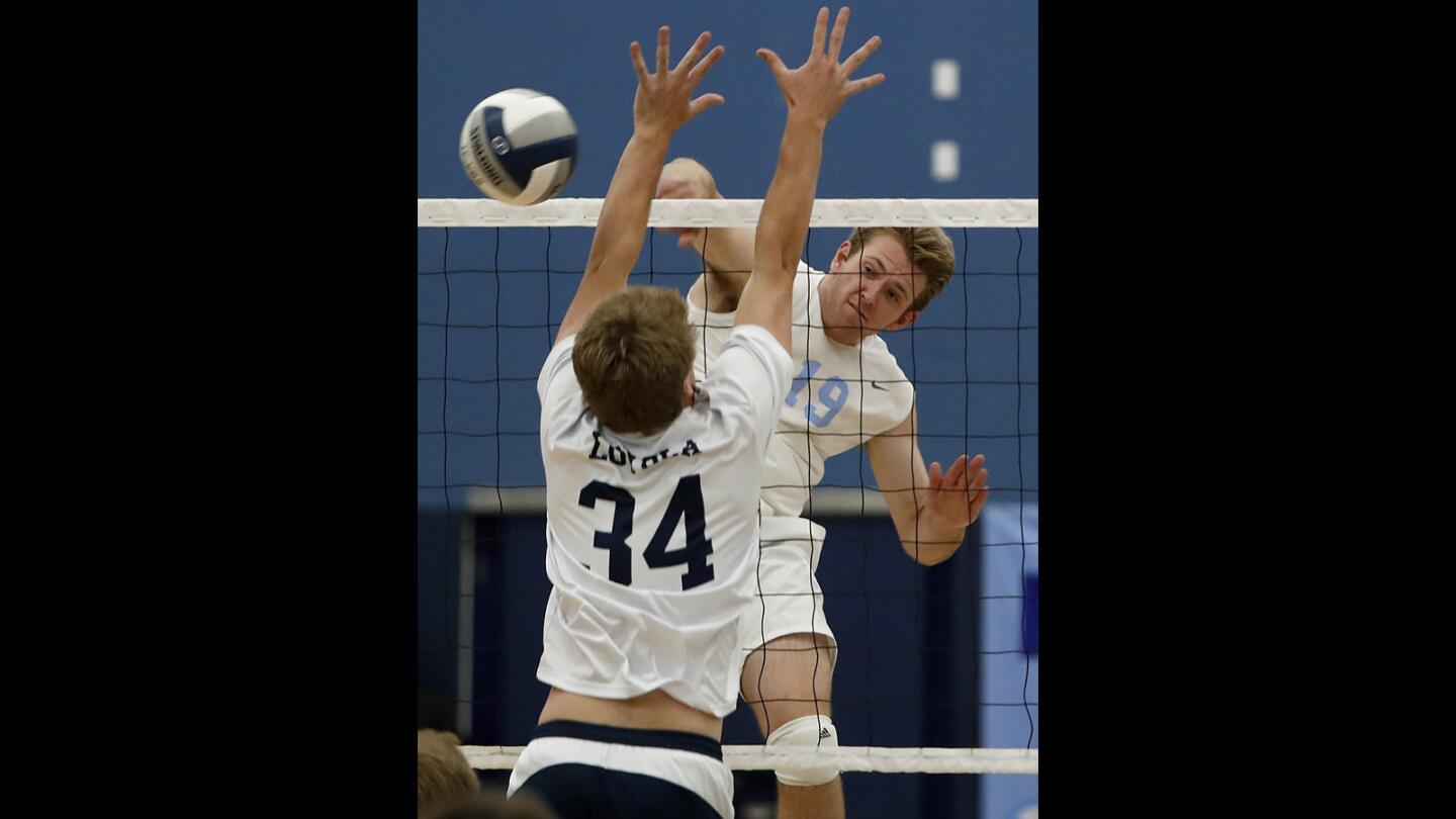Corona del Mar High's Brandon Hicks (19) scores against Loyola's Joe McNamee (34) during first set in a nonleague volleyball match on Thursday, May 3.
