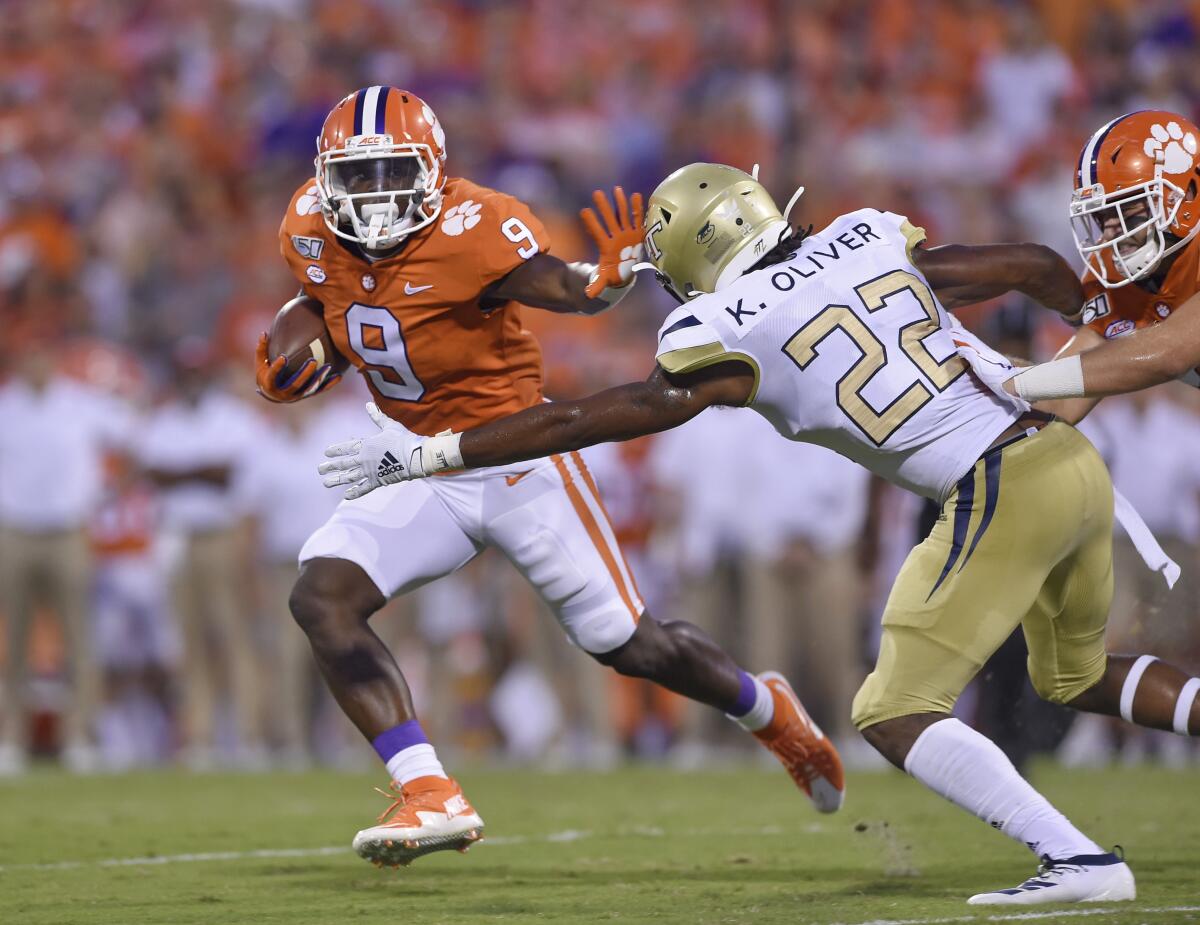 Clemson's Travis Etienne, left, fends off Georgia Tech's Kaleb Oliver to rush for a first down during the Tigers' season-opening win Thursday.