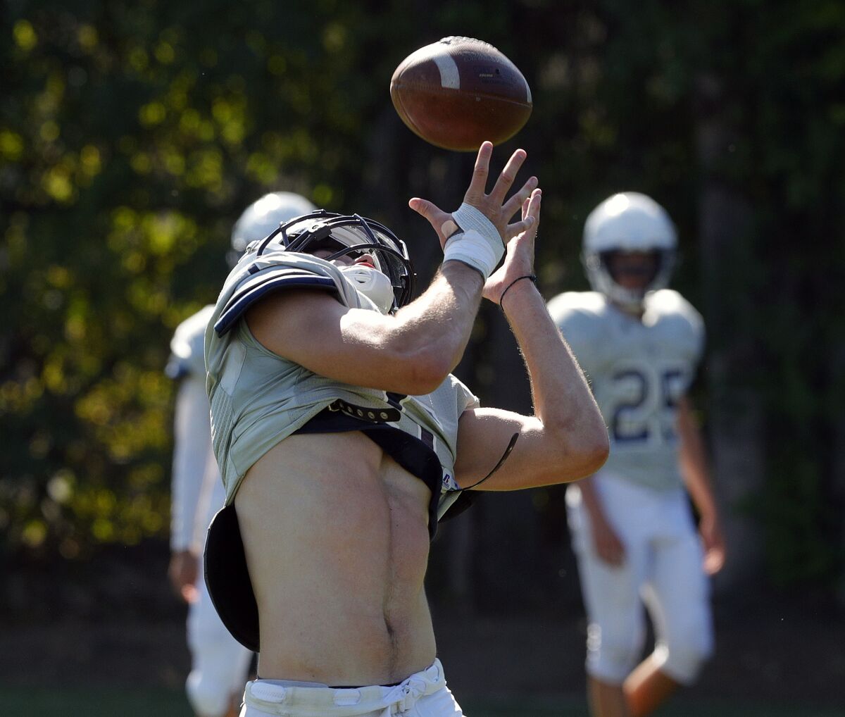 Flintridge Prep's Ben Grable looks back over his shoulder for a pass as it drops over his shoulder into his arms during a passing drill at pre-season football practice at Flintridge Prep on Monday, August 19, 2019.