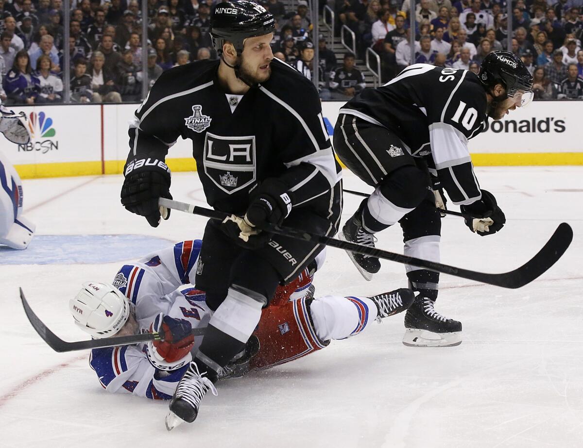 New York Rangers defenseman Raphael Diaz, bottom, clears the puck out of the defensive zone in front of Kings forward Kyle Clifford during the first period of Game 1 of the Stanley Cup Final.