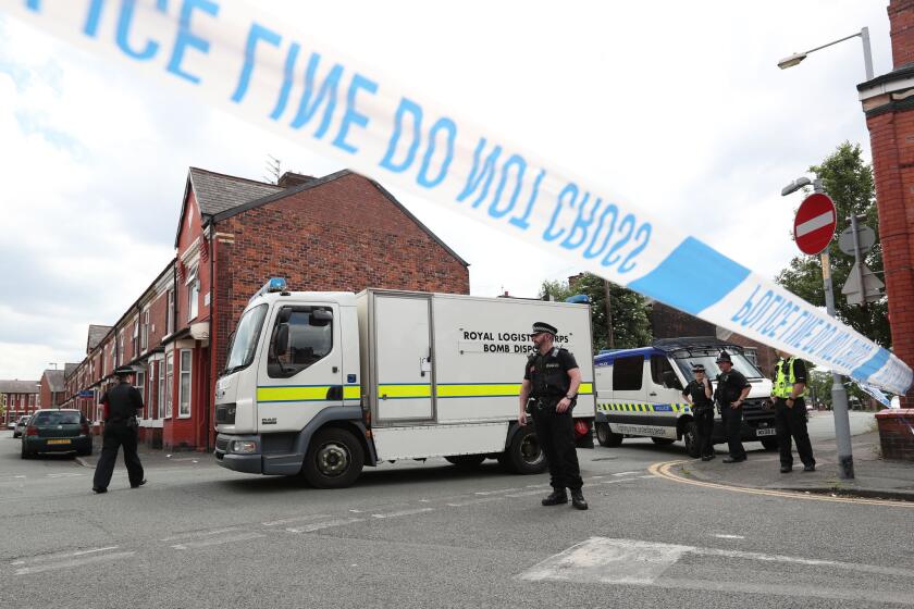 Police and a bomb disposal unit stand watch unit after an evacuation took place in the Moss Side area of Manchester, England on May 27, 2017.