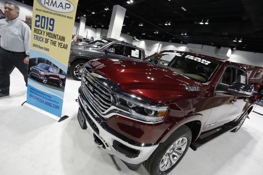 FILE - In this March 28, 2019 file photo buyers look over a 2019 Ram pickup truck on display at the auto show in Denver. Fiat Chrysler is recalling nearly 343,000 Ram pickup trucks worldwide because the air bags may not inflate in a crash. The recall covers the Ram 1500 mainly from the 2019 model year, although the company has a small number of 2020 models. (AP Photo/David Zalubowski)