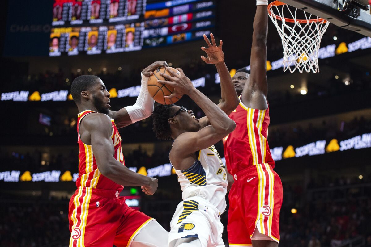 Indiana Pacers forward Jalen Smith shot is blocked between Atlanta Hawks forward AJ Griffin as center Clint Capela, right, defends during the second half of an NBA basketball game, Saturday, March 25, 2023, in Atlanta. (AP Photo/Hakim Wright Sr.)