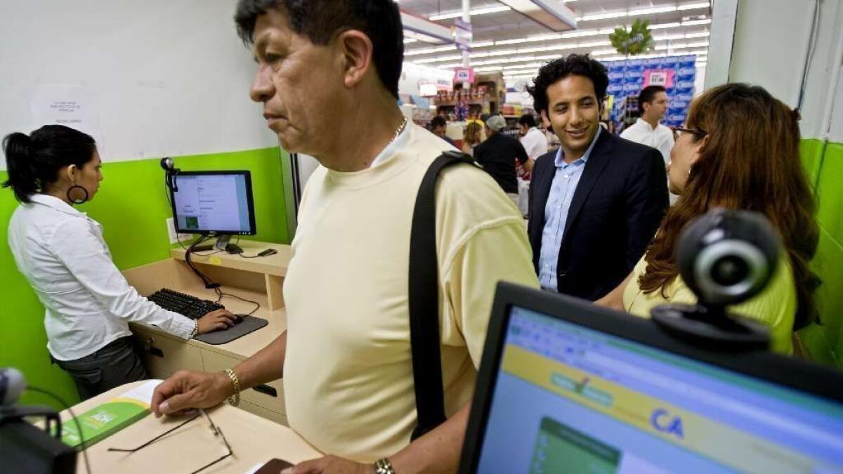 James Gutierrez, second from right, at a grocery store lending kiosk. His company, Insikt, makes loans of up to $2,500 through grocery stores and other businesses.