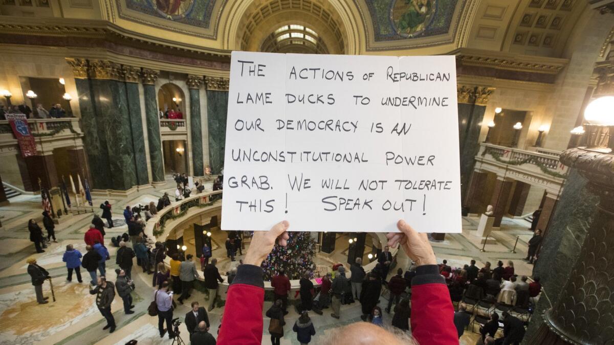 People protest the legislature's session during the official Christmas tree lighting ceremony at the Capitol in Madison, Wis., on Tuesday.