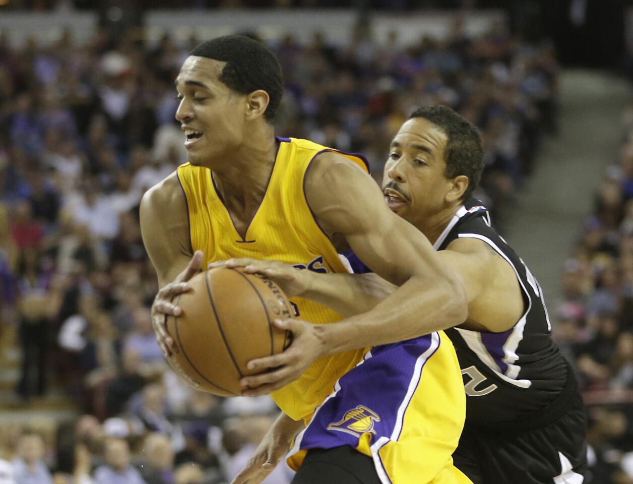 Kings veteran guard Andre Miller reaches around Lakers point guard Jordan Clarkson to try to steal the ball.