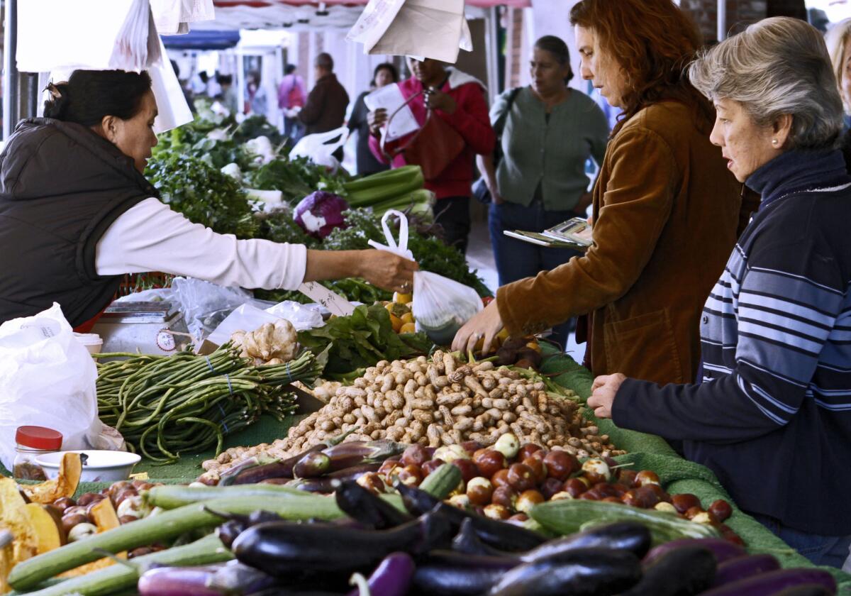 People shop for fresh vegetables and fruits at the downtown Farmers Market on Brand Blvd. in Glendale on Thursday, Oct. 10, 2013. The city of Glendale is looking into the possibility of handing over the operation of the Farmer's Market to the Downtown Glendale Association.